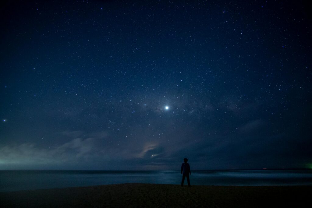 Silhouette of a person standing alone under a starry night sky, representing the fear of vulnerability and the search for stoic peace in a chaotic world.