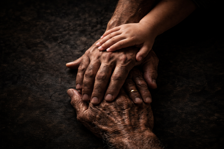 Three generations of hands stacked together, representing the transition from Jaimini's philosophy of action to Maharishi Badrayan's Vedanta philosophy of being.